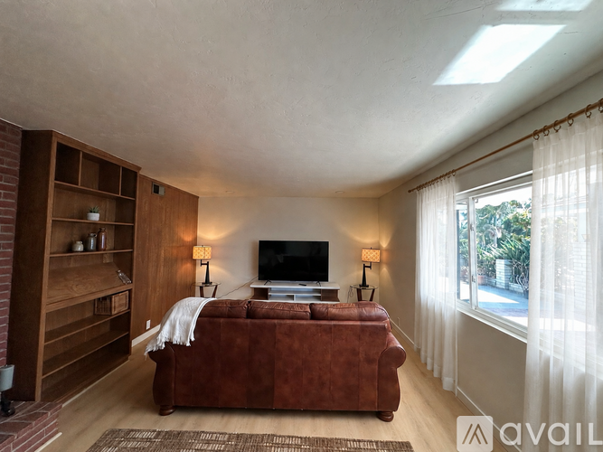 A living room with a red couch and a flat screen TV.