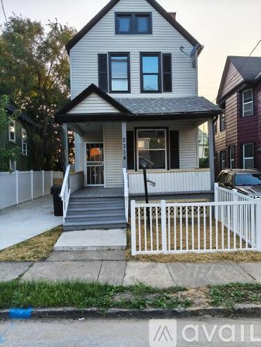 A two-story house with a white picket fence in front.
