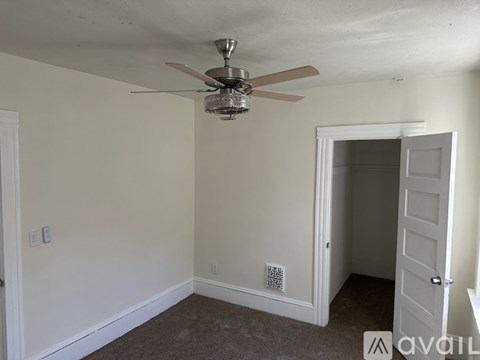 A room with a ceiling fan and a carpeted floor.