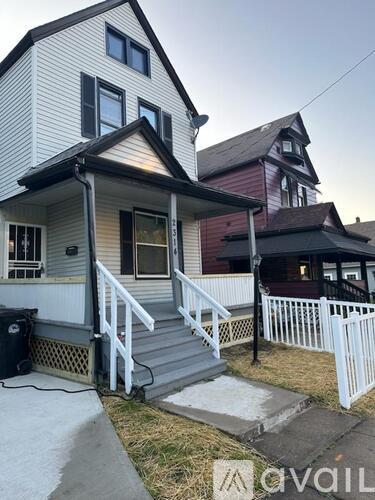 A house with a white fence and a grey porch.