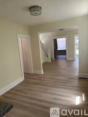 A hallway with a bench and a light fixture on the ceiling.
