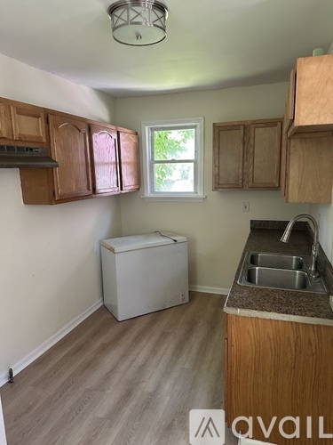 A kitchen with wooden cabinets and a white dishwasher.