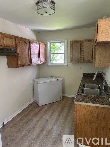 A kitchen with wooden cabinets and a white dishwasher.