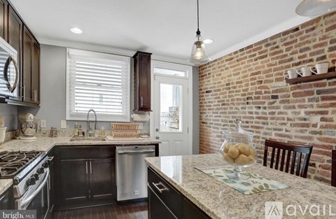 A kitchen with a brick wall and a marble countertop.