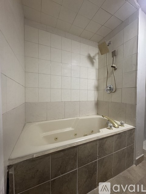 A bathroom with a white tub and a shower head.