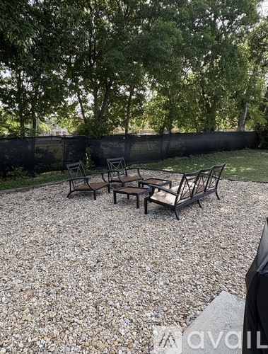 A patio with a table and chairs surrounded by a black fence.