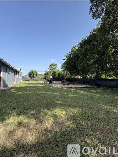 A backyard with a lawn and trees.