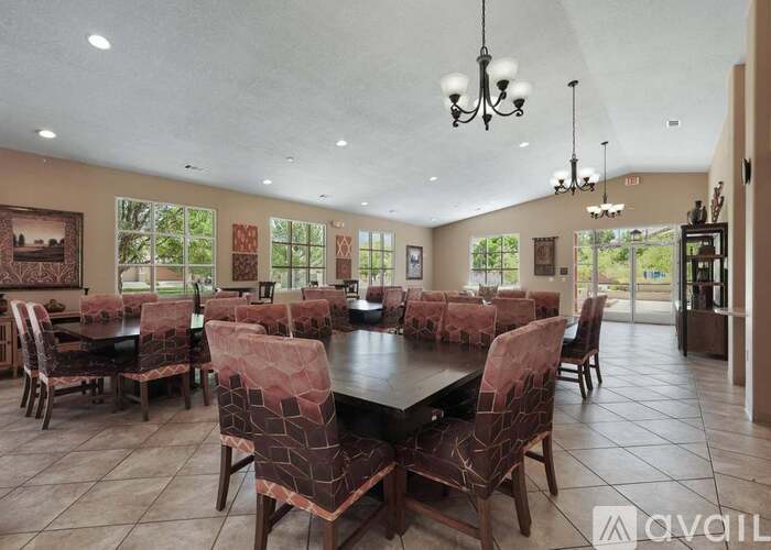 A dining room with a large table and chairs.