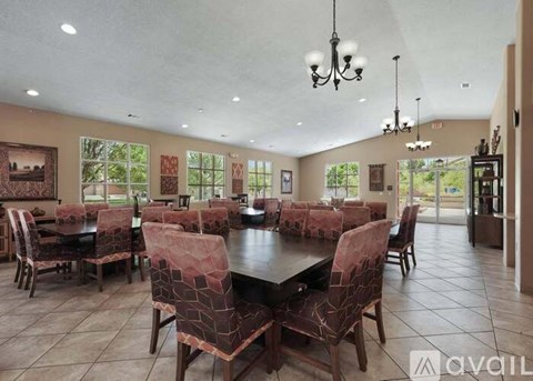 A dining room with a large table and chairs.