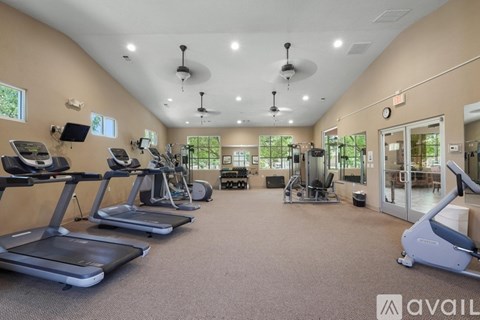 A gym with treadmills, elliptical machines, and other exercise equipment.