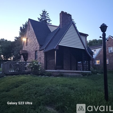 A house with a porch and a lamp post in front.