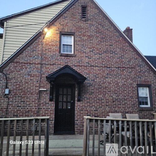 A brick house with a black door and windows.