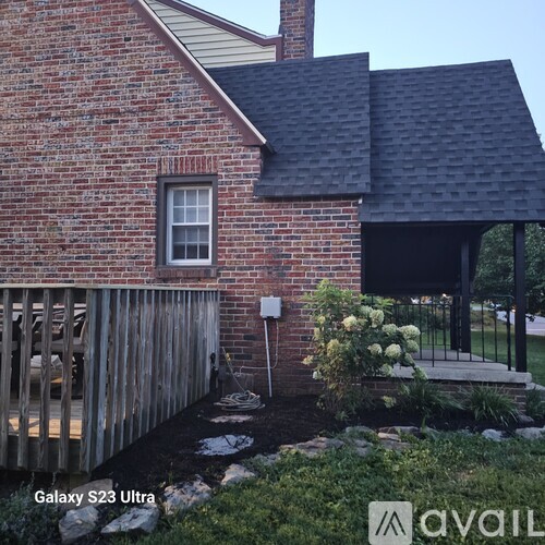 A house with a red brick exterior and a black roof.