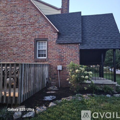 A house with a red brick exterior and a black roof.