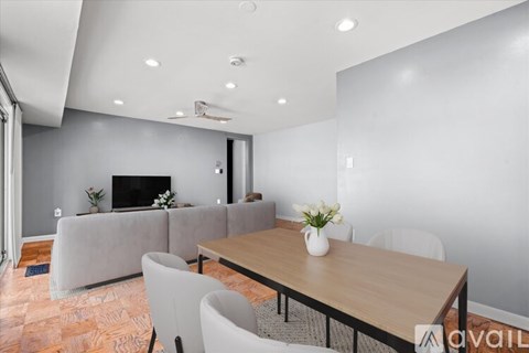 A modern dining room with a wooden table and chairs.
