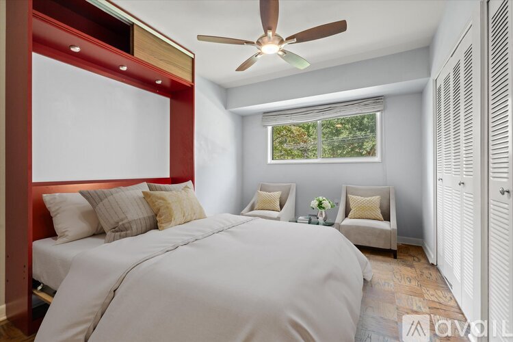 A bedroom with a large bed and a window with a view of trees.
