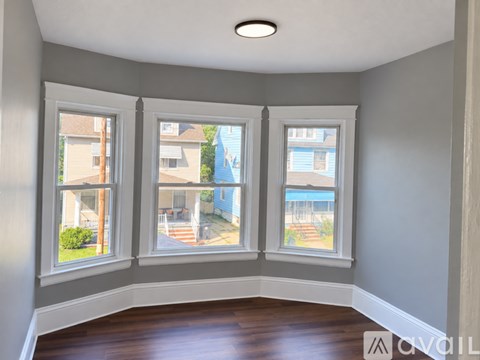 A room with a window overlooking a residential area.