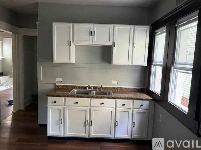 A kitchen with white cabinets and a granite countertop.