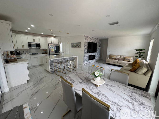 A modern kitchen with a marble floor and a dining table set for two.