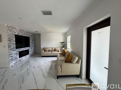A modern living room with a stone fireplace and a large couch.
