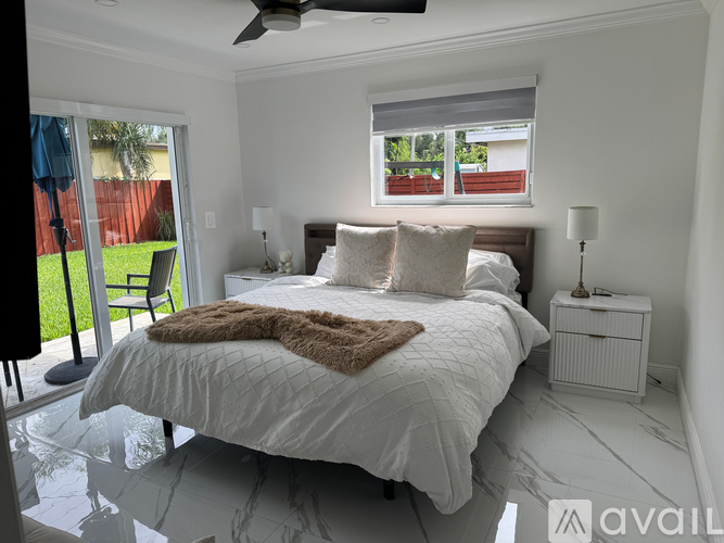 A bedroom with a large bed and a ceiling fan.