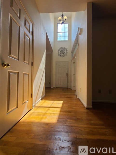 A hallway with a wooden floor and a white door.