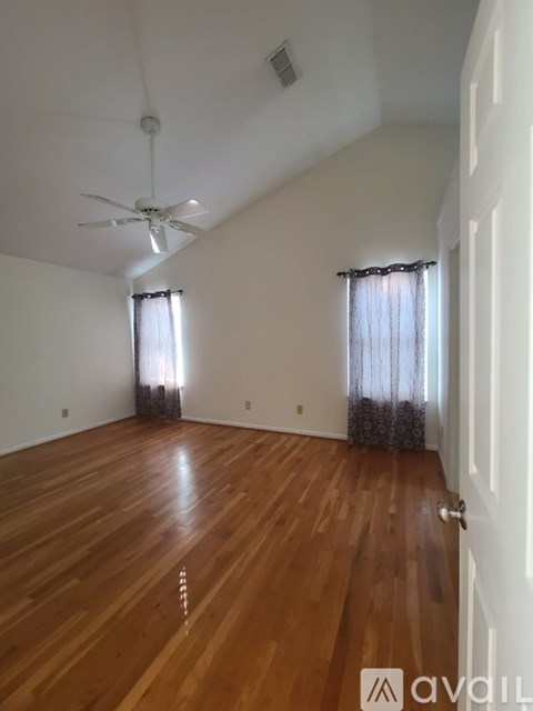 A room with wooden flooring and a ceiling fan.