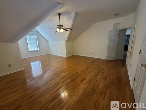 A room with wooden flooring and a ceiling fan.