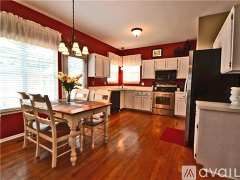 A kitchen with a table and chairs in front of a window.