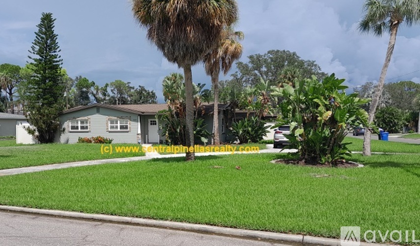 A house with a green lawn and trees in front.
