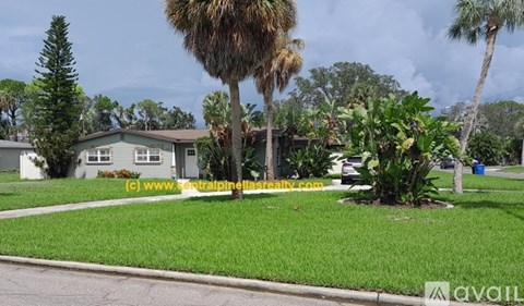 A house with a green lawn and trees in front.