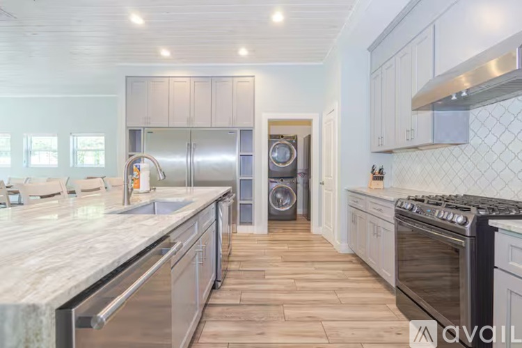 A kitchen with a marble countertop and stainless steel appliances.