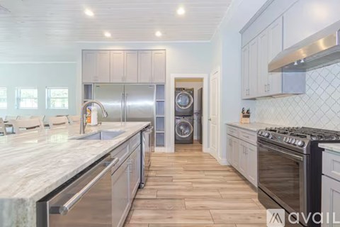 A kitchen with a marble countertop and stainless steel appliances.