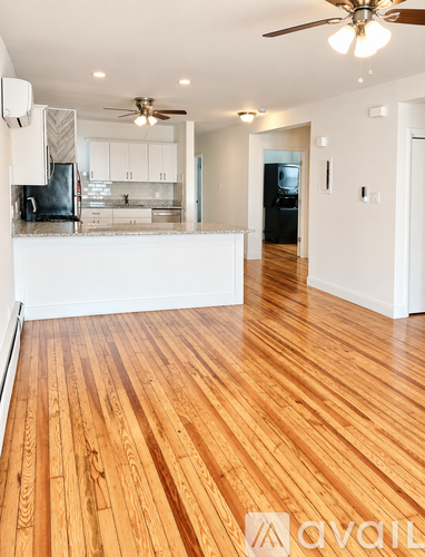 A room with wooden floors and a ceiling fan.