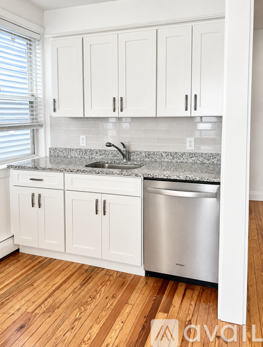 A kitchen with white cabinets and a granite countertop.