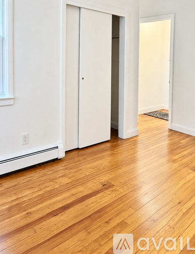 A room with a wooden floor and a white door.