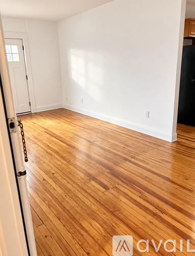 A room with wooden flooring and a white door.