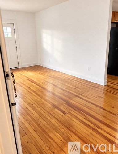 A room with wooden flooring and a white door.
