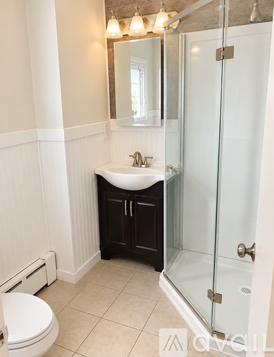 A small bathroom with a sink, toilet and shower.