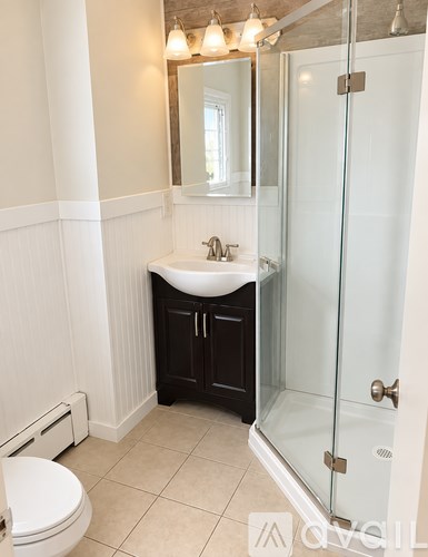 A small bathroom with a sink, toilet and shower.