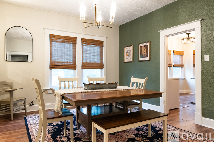 A dining room with a wooden table and chairs.