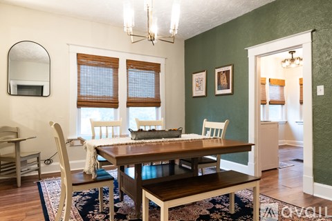 A dining room with a wooden table and chairs.