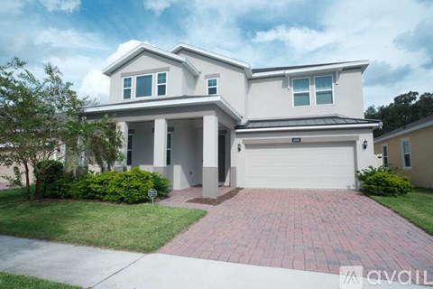 A two-story house with a garage and a driveway.
