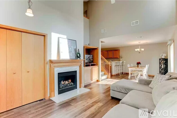 A living room with a fireplace and a dining area in the background.