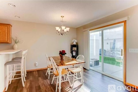 A dining room with a wooden table and chairs.