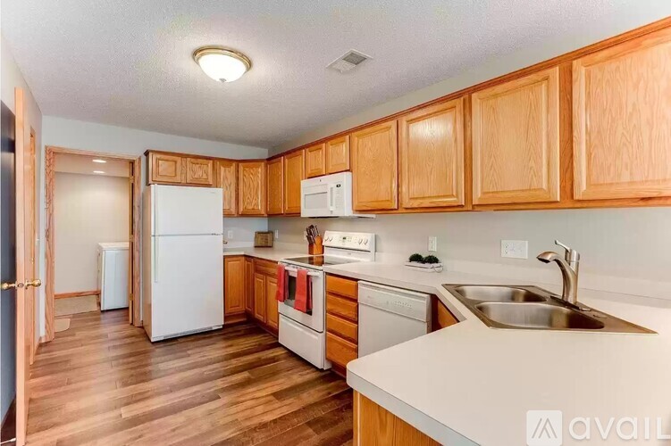 A kitchen with wooden cabinets and white appliances.