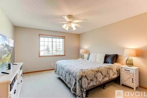 A bedroom with a bed, dresser, and window.