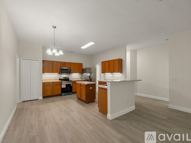 A kitchen with wooden cabinets and a white countertop is available for rent.