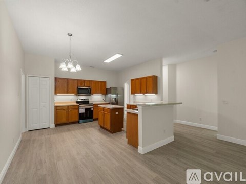 A kitchen with wooden cabinets and a white countertop is available for rent.