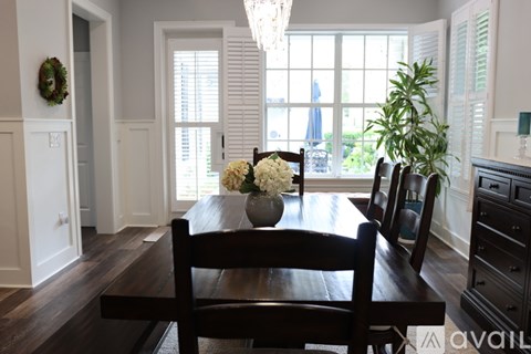 A dining room with a wooden table and chairs.